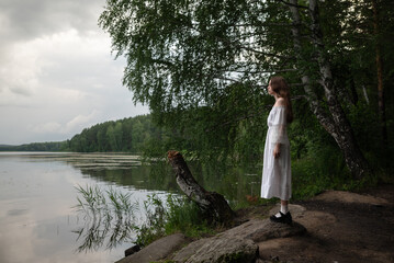 Whispers of Nature: Woman in White Dress Contemplating by the Lake