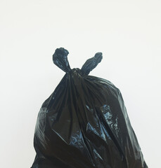 A black plastic bag full of garbage on a white background