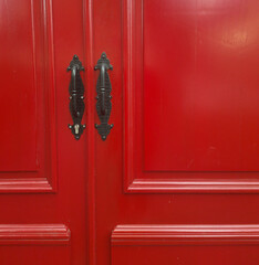 two red door leaves made of wooden panel.