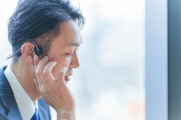 オフィスで打ち合わせをするビジネスパーソン　骨伝導　オープンイヤー　ワイヤレス　イヤホン