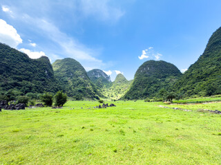 Continuous mountains landscape with green grass and clouds, Guilin, Guangxi, China