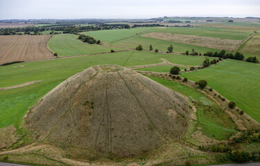 Silbury Hill prehistoric man made chalk and clay mound near Avebury stone circle henge, England. 39m high. Earliest dates from 2400BC. View from S