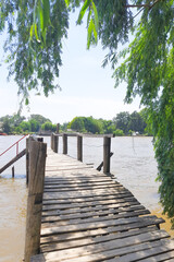 a wooden bridge over the water on a summer day
