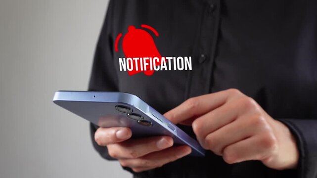 Executive interacting with her cell phone screen with a notification bell animation