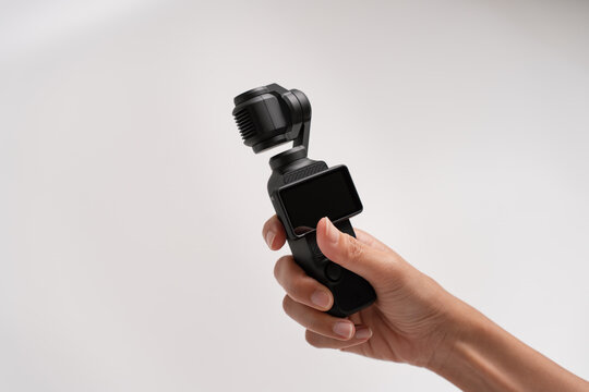 PENANG, MALAYSIA - OCT 15, 2024:  Hand holding DJI Osmo Pocket 3 with twisting the LCD in isolated white background. DJI Osmo Pocket 3 unbox.