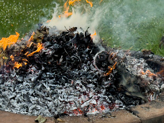 dangerously hot orange and red flames with dense black smoke consuming wood and embers