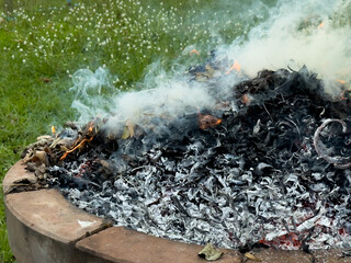 dangerously hot orange and red flames with dense black smoke consuming wood and embers