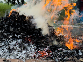 dangerously hot orange and red flames with dense black smoke consuming wood and embers