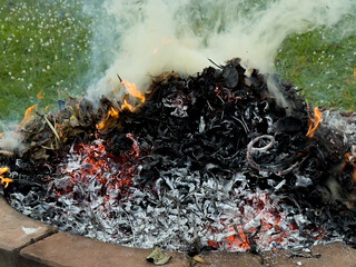 dangerously hot orange and red flames with dense black smoke consuming wood and embers