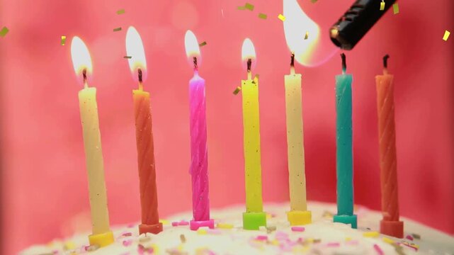 Seven candles on cake being lit after lighter nozzle lighting wicks, confetti falling for birthday