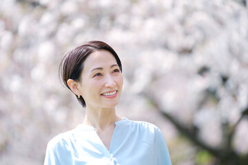 満開の桜と散歩する女性