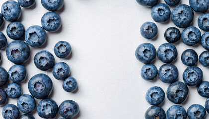 Fresh blueberries scattered on a white surface healthy food concept.