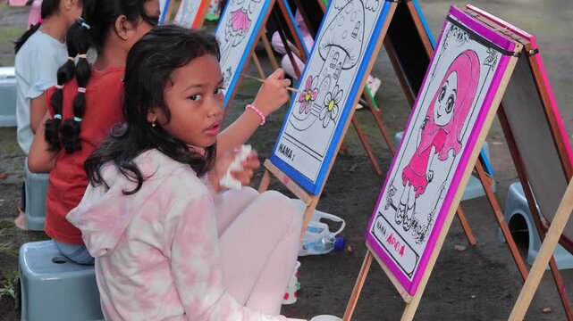 Young Children Focusing on Creative Coloring Activity Outdoors - Cinematic at Mataram, Indonesia - December 7, 2025