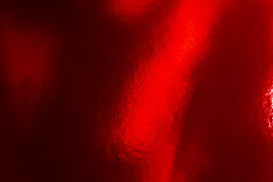 Lunar New Year. Shiny red lacquer texture with light reflections. Foil Texture Background. glare on a red surface.Red Metallic Foil Texture Background. Red festive background. 