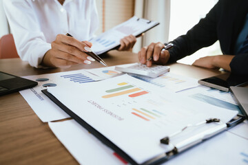 Two professionals review financial charts and analytics together during a business meeting.