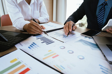 Two professionals review financial charts and analytics together during a business meeting.