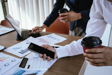 Business team analyzing financial charts and using a calculator during a meeting.