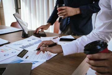 Business team analyzing financial charts and using a calculator during a meeting.