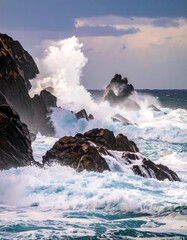 Ocean waves crashing against dark rocks under a cloudy sky