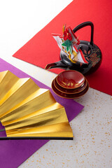 お屠蘇と扇と和風の敷物のイメージ　