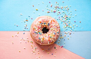 A donut with sprinkles on a multi-colored background