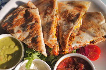 Delicious quesadillas with sides on a plate