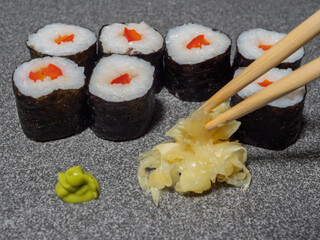 Sushi Rolls with Wasabi and Pickled Ginger on Gray Background