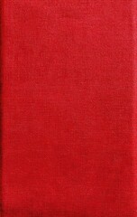 Close-up of a rectangular object, likely a book cover, displaying a textured red surface