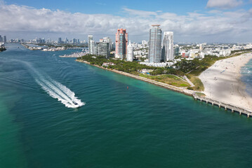 Luxury yacht cruising near Miami skyline. Aerial view of boats on turquoise waters in Miami. Yacht...