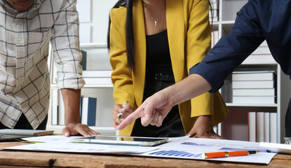 Business people working using tablet and documents in office meeting discussing strategy. Business colleagues collaborating on a project while analyzing financial statistics in office.