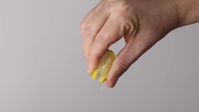 Close-Up of Fingers Squeezing a Lemon Slice