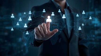 Businessman hand touching a glowing human icon on a digital world map interface representing global networking, human resource management, and social connection technology