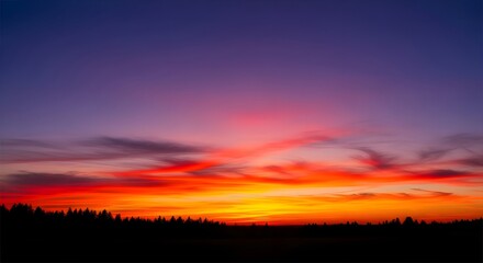 Fototapeta premium Dramatic sunset sky with vibrant colors and silhouetted trees