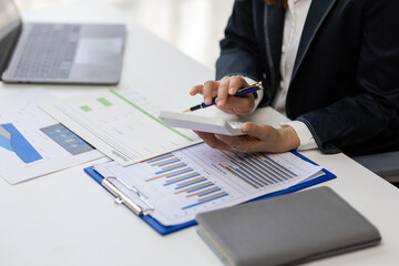 Businesswoman analyzing financial documents at office desk.