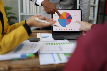 Business people analyzing financial chart on tablet during corporate meeting.