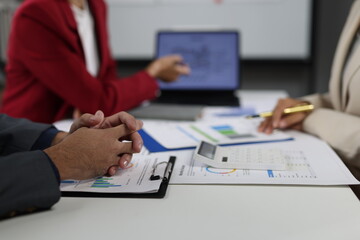 Business people analyzing financial charts and graphs using calculator and tablet, discussing company financial strategy and making profitable investment plan.
