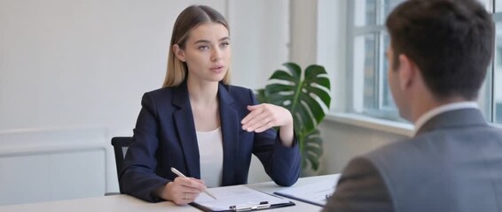 Professional Dialogue: Capturing a moment of insightful professional exchange between two individuals in a bright office environment. Focused on the dynamic of the conversation.