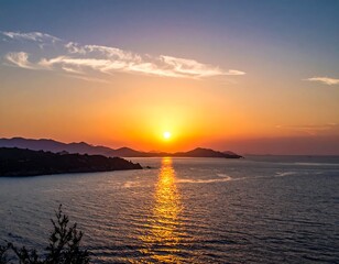 Obraz premium Sunset over ocean with mountains, cloud, and shimmering sunlight