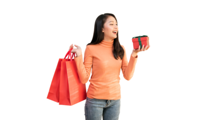 Happy Asian woman holding red shopping bags and gift box for Christmas and New Year holiday shopping.