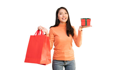 Happy Asian woman holding red shopping bags and gift box for Christmas and New Year holiday shopping.