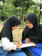 Mother Helping Daughter with Homework in Nature