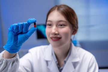 Fototapeta premium Scientist holding a pill in laboratory setting, smiling at the discovery