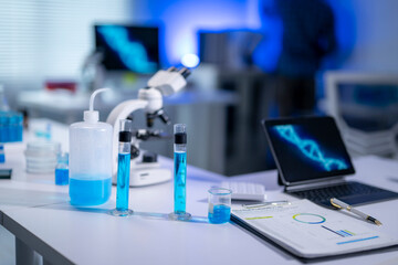 Medical research laboratory equipment displaying blue chemical liquid and dna structure