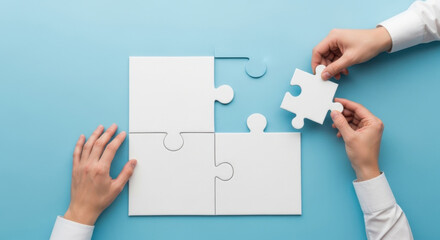 Close-up of hands completing a white jigsaw puzzle, flat lay on light blue backdrop. Concept of connection, teamwork and solutions in bright studio lighting.