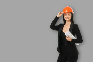 Woman stands with construction plans in gray backdrop