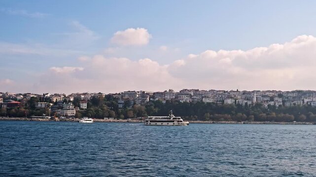 A scenic seascape of Istanbul's historic Sarayburnu point. A ferry crosses the water with the ancient walls of Topkapi Palace and lush trees in the background.