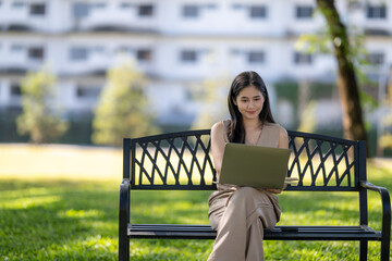Woman working on laptop remote in urban park