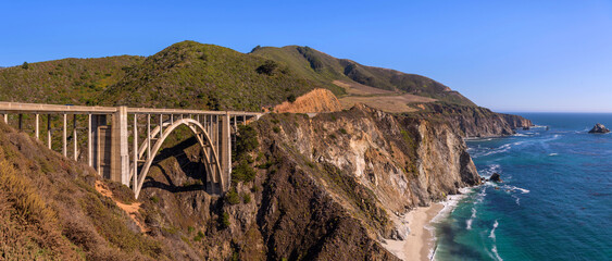 Bixby Bridge - A panoramic view of Bixby Bridge, on State Route 1 along the rocky and scenic central coastline, on a sunny Summer evening. Big Sur, Monterey, California, USA.