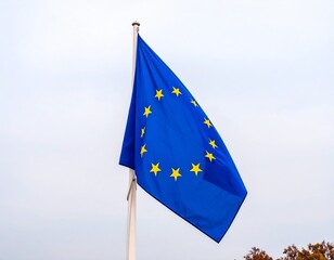 The flag of the european union, with its circle of stars, waving against a sunset whi 