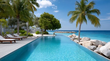 Fototapeta premium Infinity pool blending with tropical ocean resort view